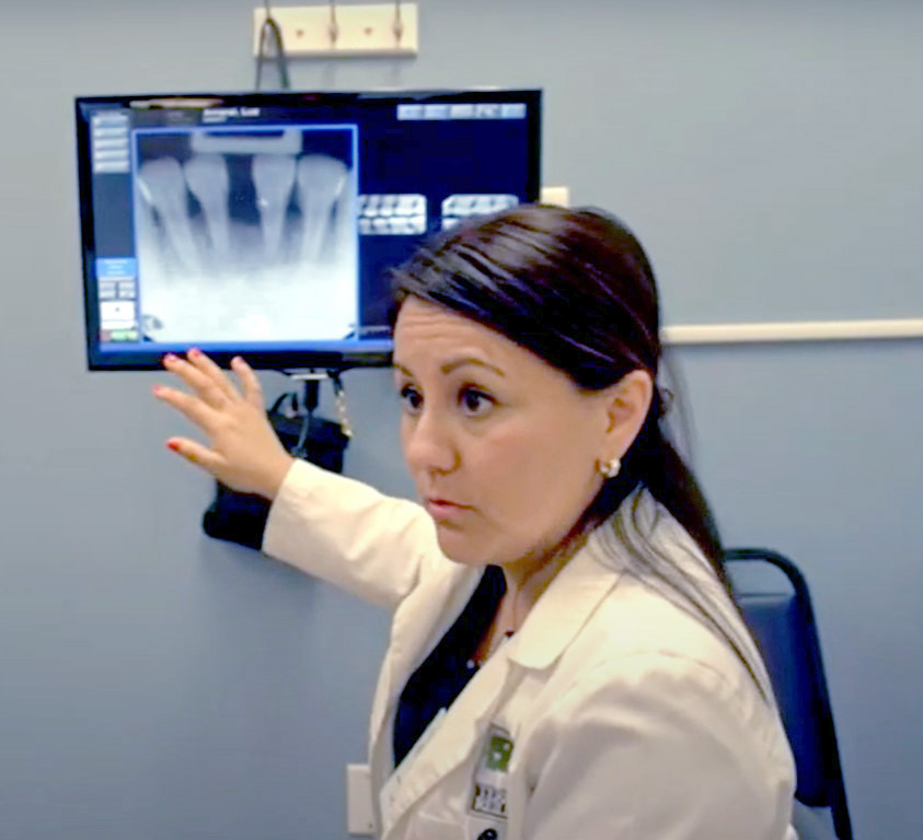 NHSC Loan Repayment Program recipient, Dr. Maria Martinez pointing to a dental x-ray